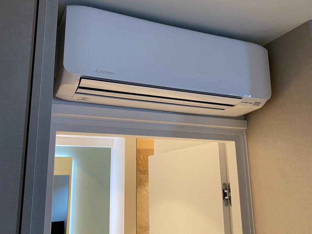 Mitsubishi airco binnenunit strak boven een deur gemonteerd, door AITL