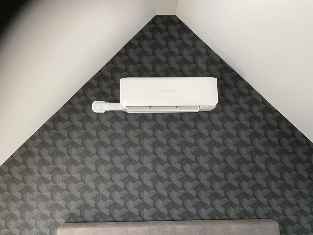Mitsubishi airco op een schuine wand in een slaapkamer, door AITL